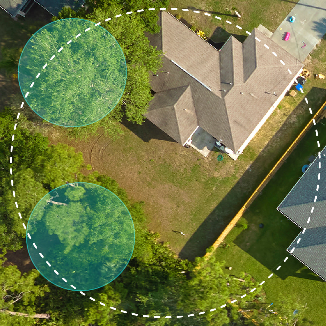 Aerial view of a house with a backyard, surrounded by trees and colorful circular overlays, representing mosquito trap reach