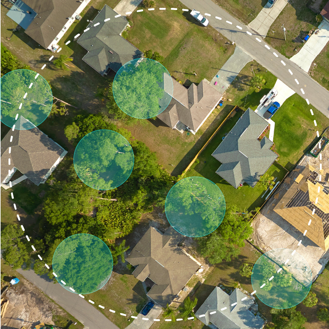 Aerial view of a house with a backyard, surrounded by trees and colorful circular overlays, representing mosquito trap reach