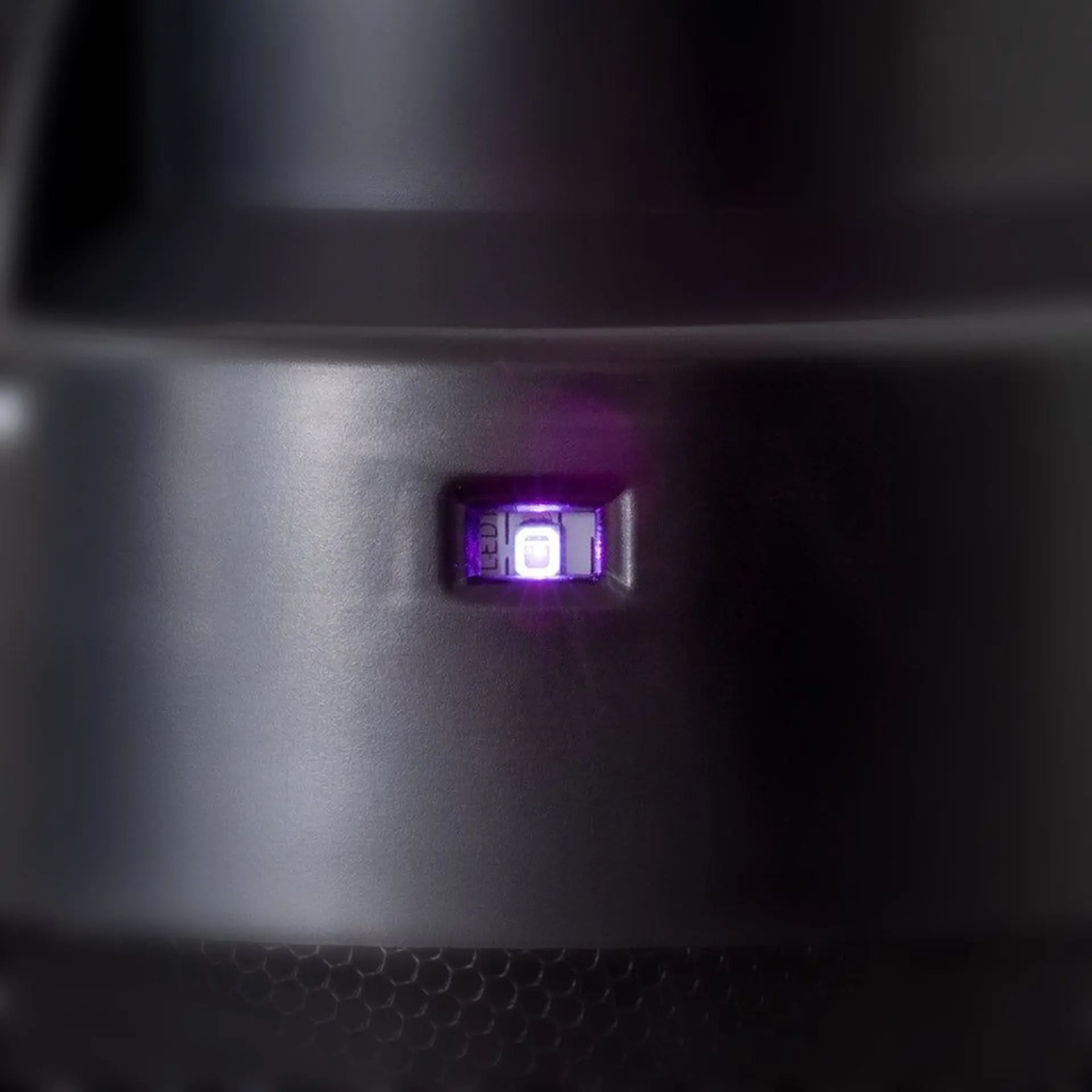 Close-up of LED indicator light on a black electronic device.