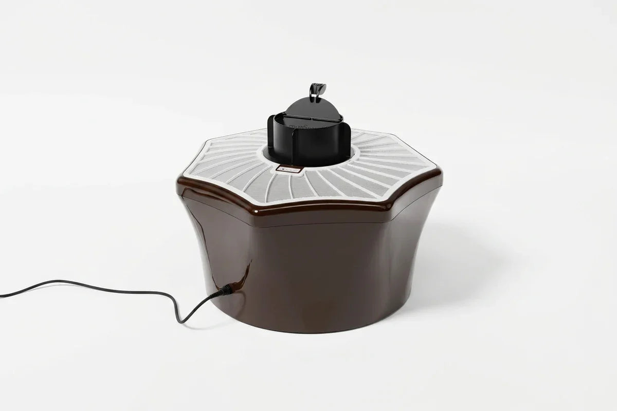 Glossy dark countertop appliance with a white radial grille, raised lid, and power cord.